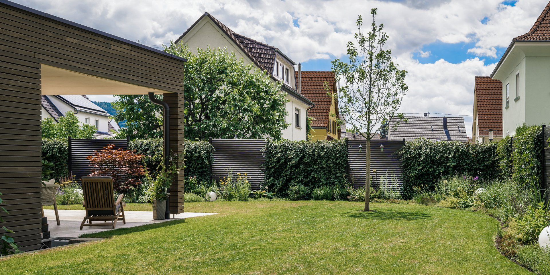 Moderner Privatgarten in Tuttlingen-Möhringen mit gepflegter Rasenfläche, überdachter Terrasse, Sichtschutzhecken und harmonischer Bepflanzung.